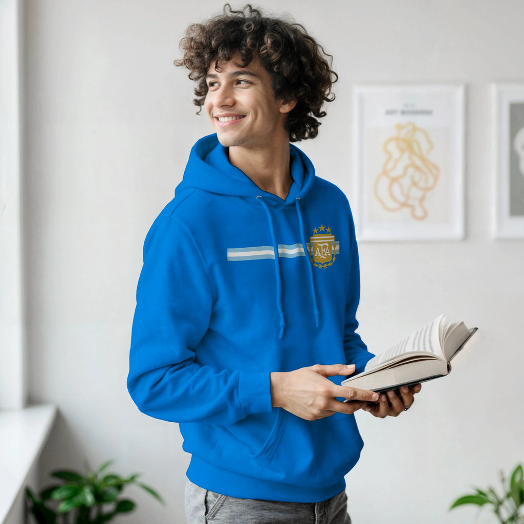 Person wearing a blue hoodie holding an open book indoors.
